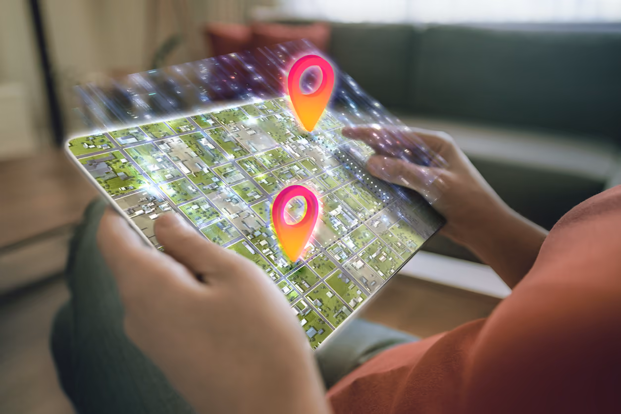 A woman holding a tablet with a digitized illustration of a map demonstrating a relocation from one home to another.